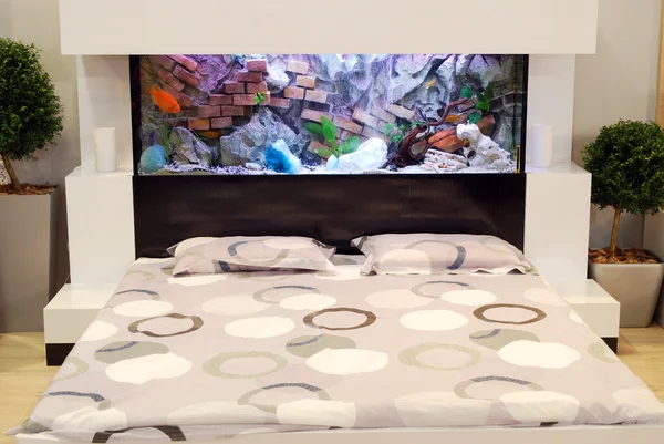 Bedroom with aquarium over bed — Stock Photo, Image