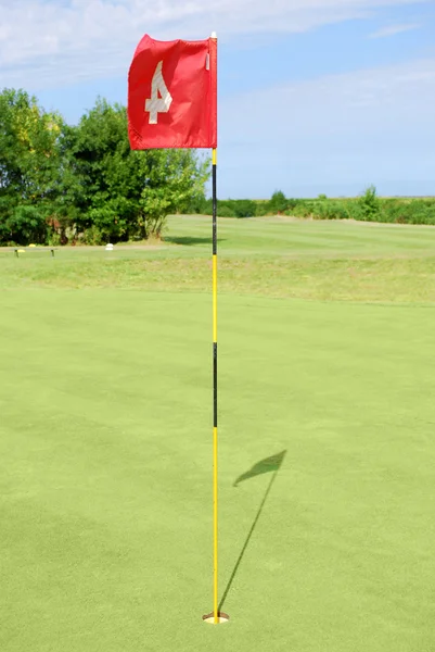 Campo de golf verde con bandera roja — Foto de Stock