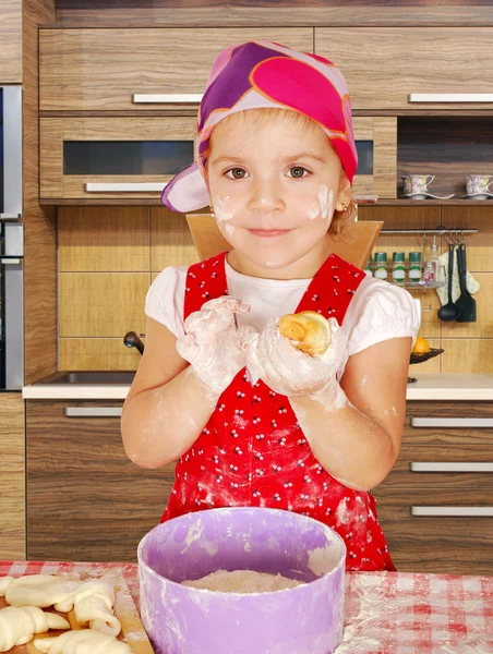 キッチンで小さな女の子が作るロールします — ストック写真