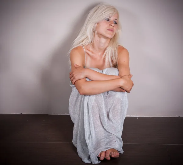 Traurige Frau Sitzt Der Leeren Wand — Stockfoto