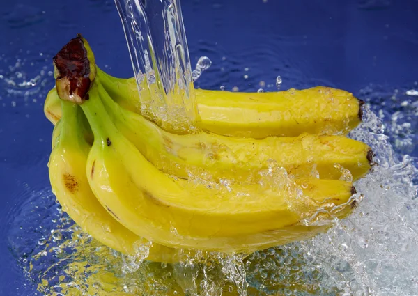 Μπανάνα Και Splash Νερό Πάνω Από Μπλε Φόντο — Φωτογραφία Αρχείου