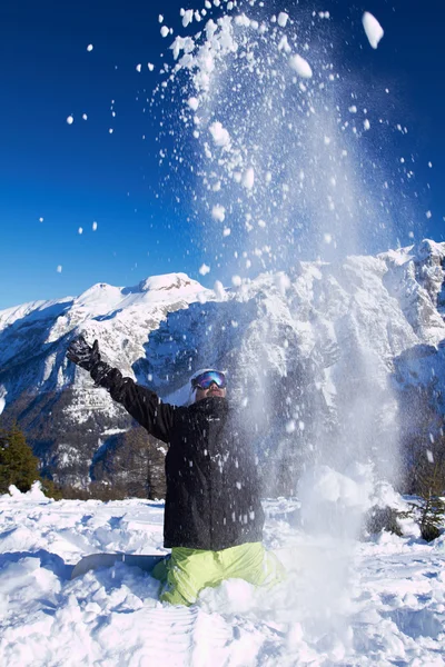高い山では空気中に雪を投げて大人の男 — ストック写真