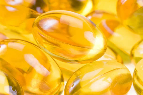 Átlátszó arany halolaj tabletták közelről — Stock Fotó