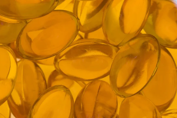 Átlátszó arany halolaj tabletták közelről — Stock Fotó