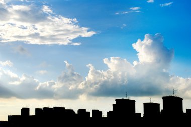 Blue sky, white clouds and building silhouette clipart