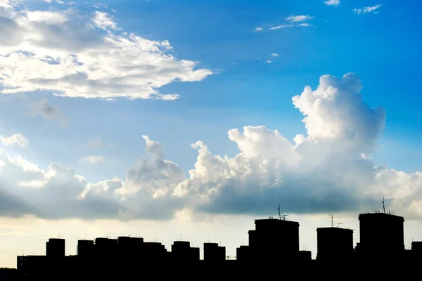Blue sky, white clouds and building silhouette — Stock Photo, Image