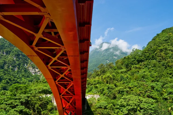 Stock image Red bridge across mountains