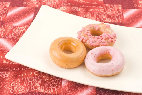 Красочные и вкусные пончики в тарелке — стоковое фото