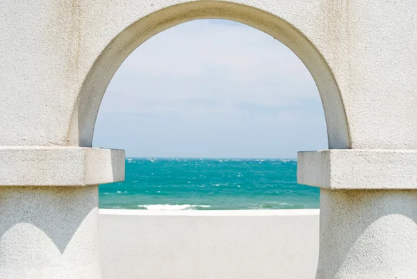 Kijken naar de Oceaan door de boog deur — Stockfoto