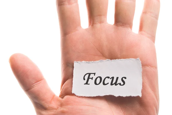 Focus word in de hand, woord op stuk scheur papier — Stockfoto