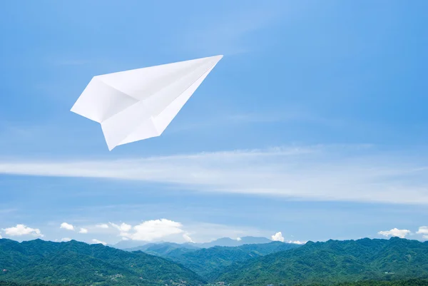 Бумажный самолет, летящий над горой — стоковое фото