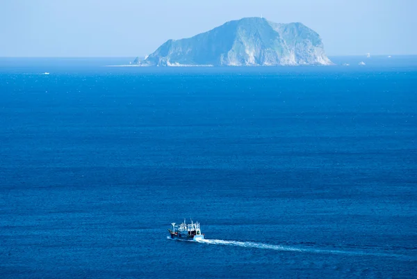 Pequeño barco pesquero pasa por la isla — Foto de Stock