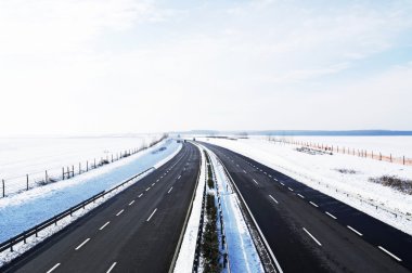Four-lane highway leads across the county in winter(Hungary) clipart