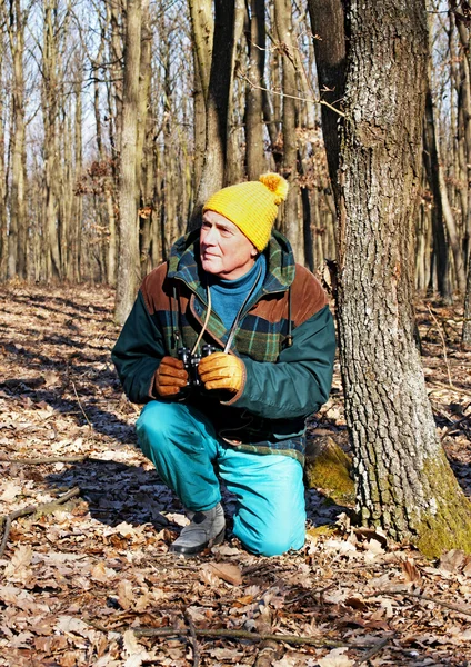 Äldre man söker djurlivet i vinter skog — Stockfoto