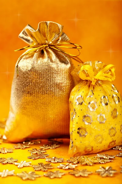 Golden christmas gift sacks and golden snowflake — Stock Photo, Image