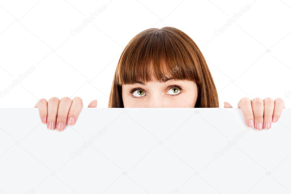 Pensive woman peeking over blank billboard