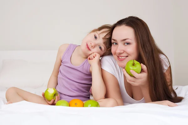 Mãe e filha comem maçãs — Fotografia de Stock