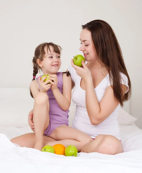 Mãe e filha comem maçãs — Fotografia de Stock