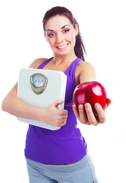 美丽的年轻女子拿秤和一个红苹果 — 图库照片