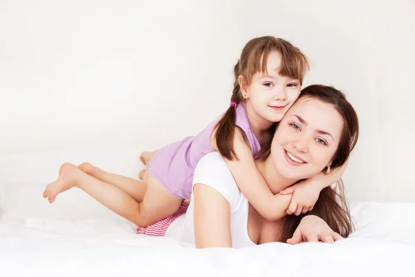 Schöne Junge Mutter Und Ihre Fünfjährige Tochter Auf Dem Bett — Stockfoto