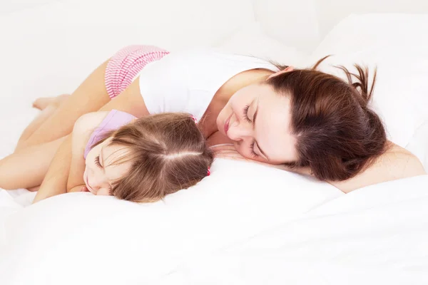 若い母親と 女性にフォーカスが自宅のベッドの上で寝る — ストック写真