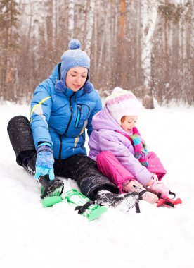 Mutlu aile; genç anne ve kızı Kayak ve kış parkta (odak yer çocuk eğleniyor)