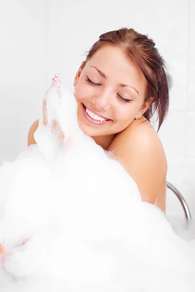 美丽的年轻黑发女子正在用泡沫轻松地洗澡 — 图库照片