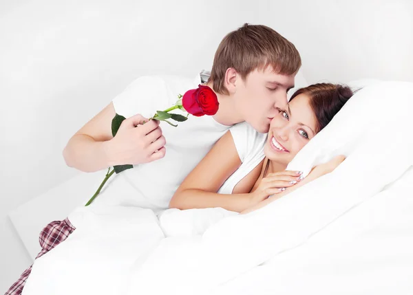 彼の美しいガール フレンドのキスをし 彼女にバラを与える若い男 — ストック写真
