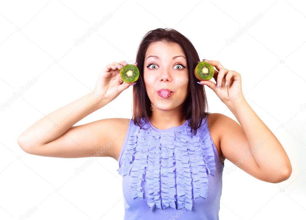 Teenage girl holding kiwi in her hands and making faces