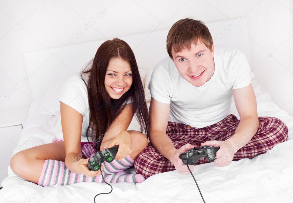 Happy young teenage couple playing computer games