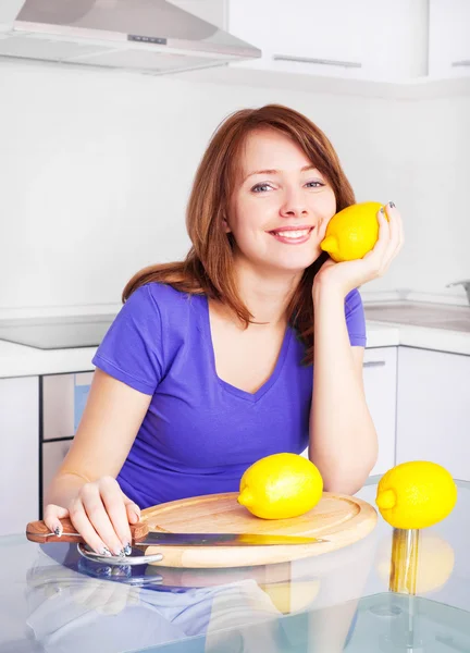 自宅の台所でレモンを持つかなり若い女性 — ストック写真