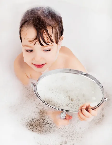 Rahatlatıcı Banyo Köpüğü Ile Aynaya Bakarak Küçük Kızla — Stok fotoğraf