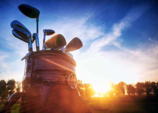 Equipamento de golfe, clubes ao pôr do sol — Fotografia de Stock
