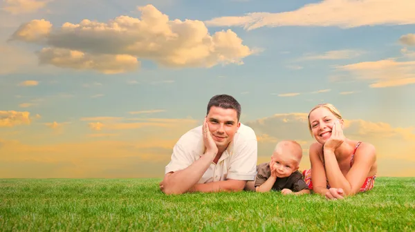 Família feliz juntos na grama — Fotografia de Stock