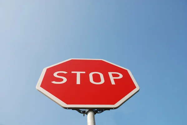 Znak stop przeciw błękitne niebo — Zdjęcie stockowe