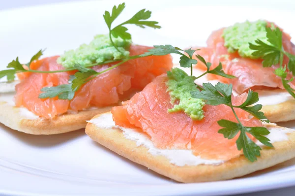 stock image Smoked salmon with wasabi on cracker isolated on white background