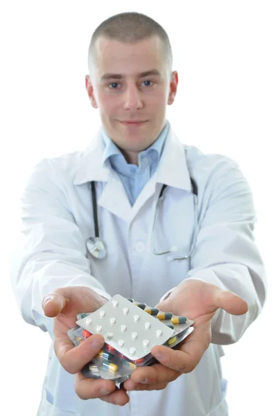 Médico joven que ofrece muchos medicamentos aislados — Foto de Stock