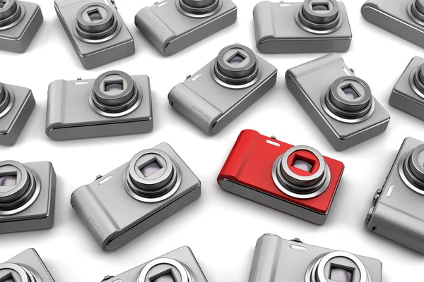 Red point and shoot photo camera among gray similar isolated on white backg — Stock Photo, Image