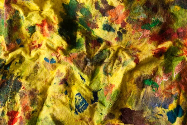 Желтая окрашенная ткань на фоне краски — стоковое фото