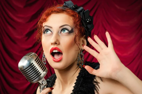 ヴィンテージのマイクに向かって歌う美しい赤毛の女性 — ストック写真