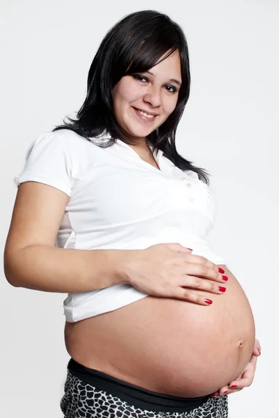Portret van de zwangere vrouw op lichte achtergrond — Stok fotoğraf