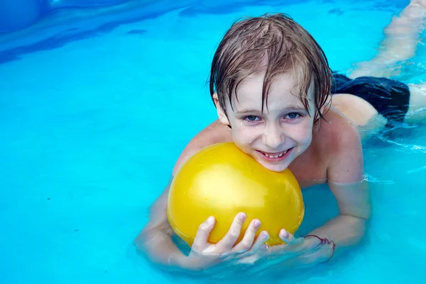 Jonge jongen zwemmen in een pool — Stockfoto
