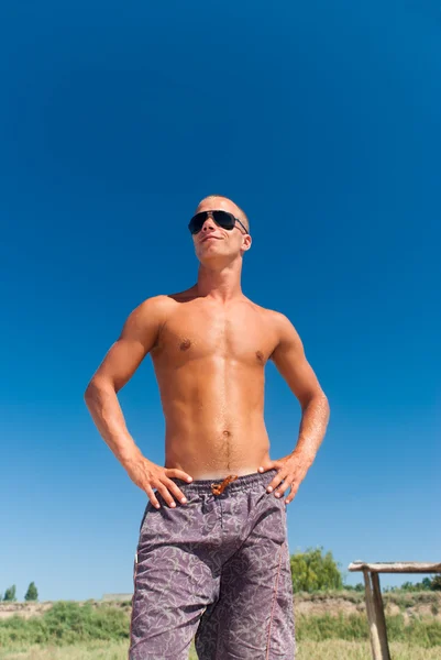 Bild eines jungen männlichen Mannes, der am Strand posiert — Stockfoto