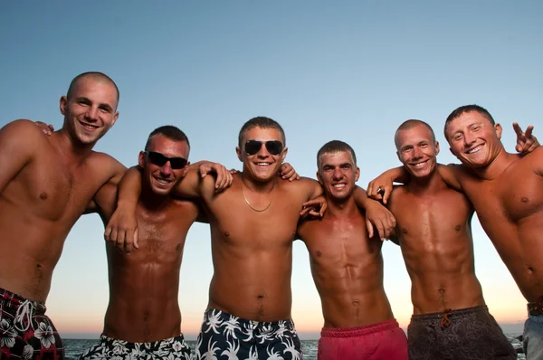 Glada team av vänner att ha kul på stranden — Stockfoto