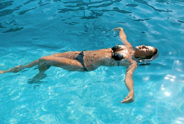 Счастливая девушка отдыхает в бассейне — стоковое фото