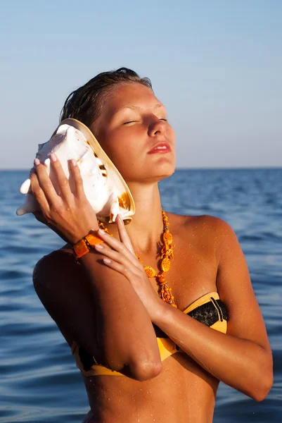 Πορτρέτο του ένα νεαρό πανέμορφο θηλυκό ακρόασης seashell τραγούδι — Φωτογραφία Αρχείου