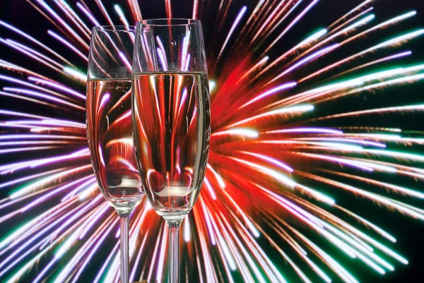 Glasses with champagne against fireworks — Stock Photo, Image