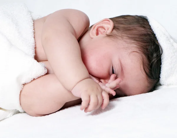 Süßes kleines Mädchen, das auf einer weißen Decke schläft. — Stockfoto