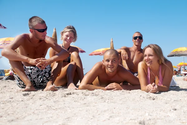 Retrato de meninas felizes e caras deitados na areia em férias de verão — Fotografia de Stock