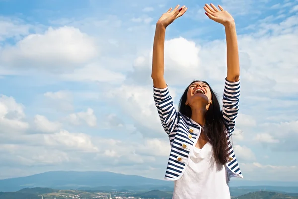 Портрет усміхненої молодої жінки підняв руки в небо — стокове фото